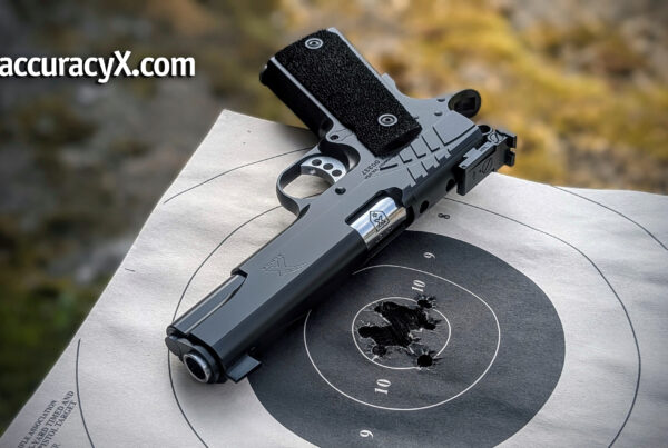 pistol laying on table on top of a used target.