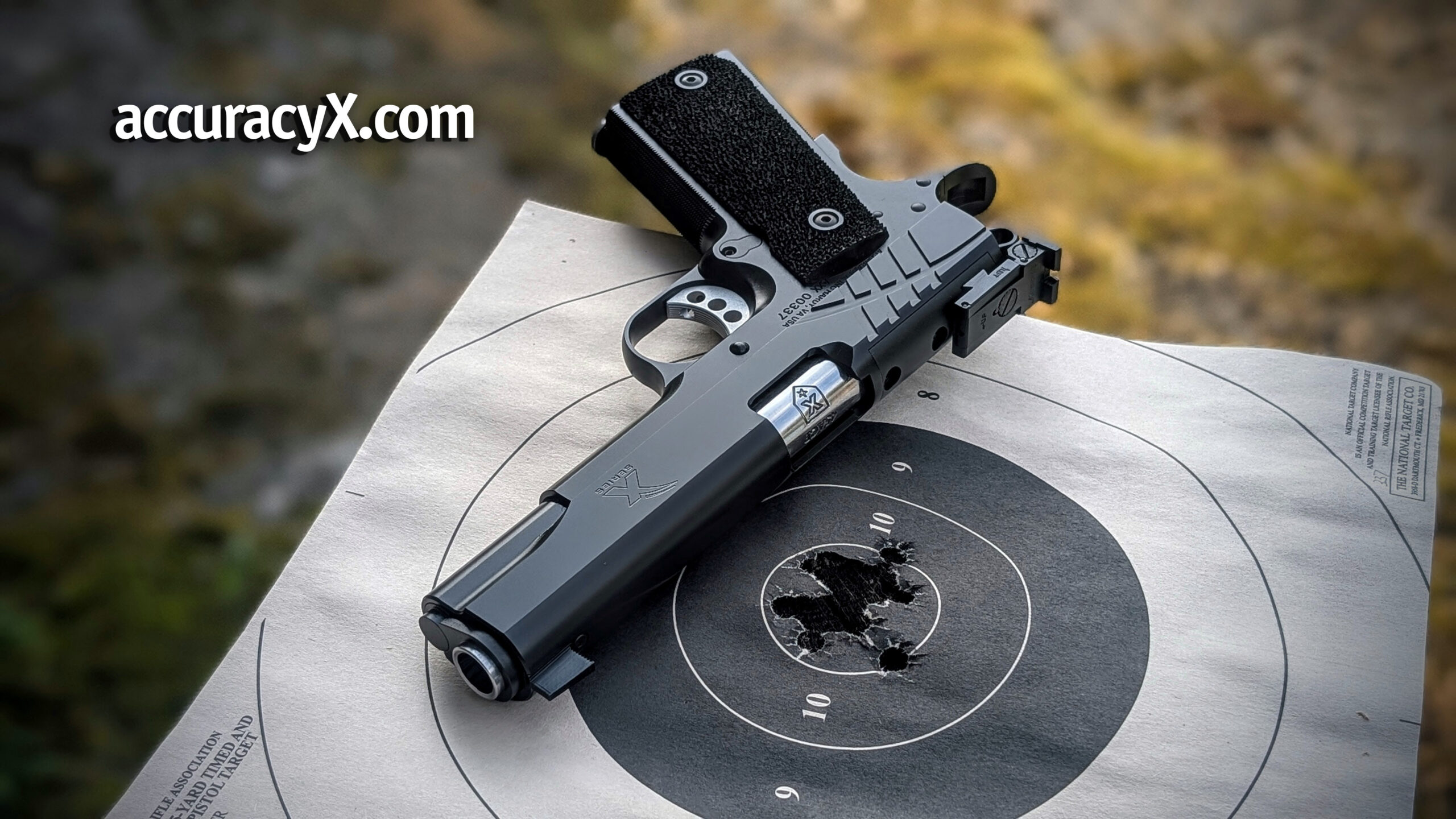 pistol laying on table on top of a used target.